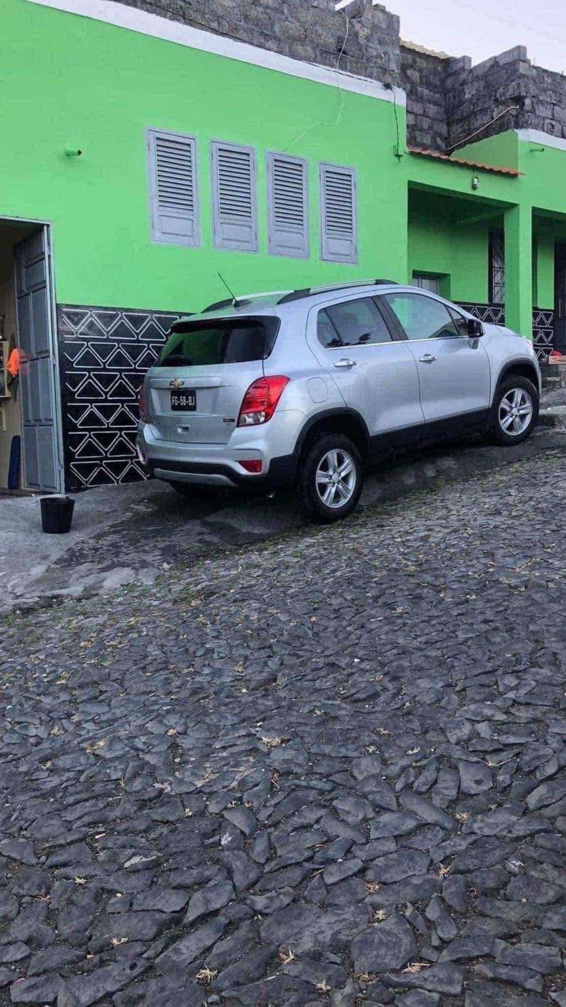 Silver 2019 Chevrolet Trax parked on a cobblestone street by a green building